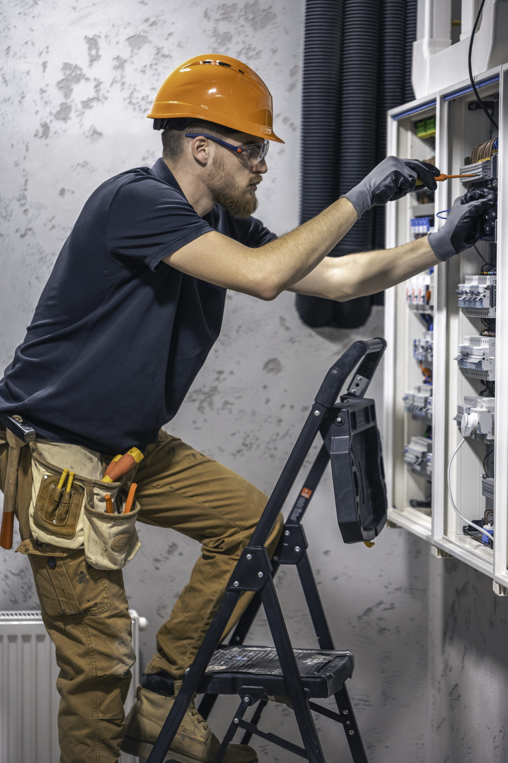 male electrician works switchboard with electrical connecting cable 2 scaled